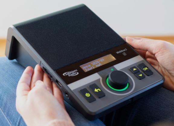 Kuuntelulaite henkilön sylissä.